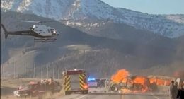 Rescue workers and a helicopter at the scene of a fiery vehicle collision.