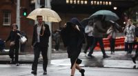 People are seen braving the rain on Friday, 23 May, 2025. The coastal trough responsible for bringing record rain to northern NSW has become more mobile after it was parked for days over soaked catchments. Picture - Sam Mooy / The Sydney Morning Herald