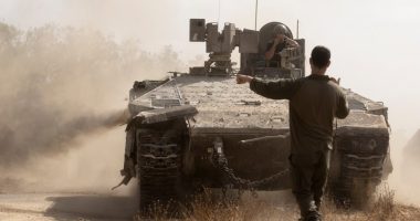 Israeli soldier directing an armored personnel carrier near the Gaza Strip border.