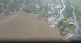 Aerial view of an avalanche destroying buildings in a village.