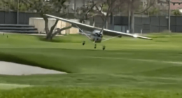 Small plane landing on a golf course.