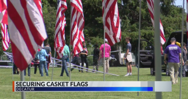 Three Decatur men protecting casket flags at cemetery