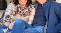 Alan and Karen Carter sitting together outdoors with wine.