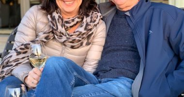 Alan and Karen Carter sitting together outdoors with wine.