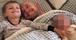 Father and two children lying in bed.