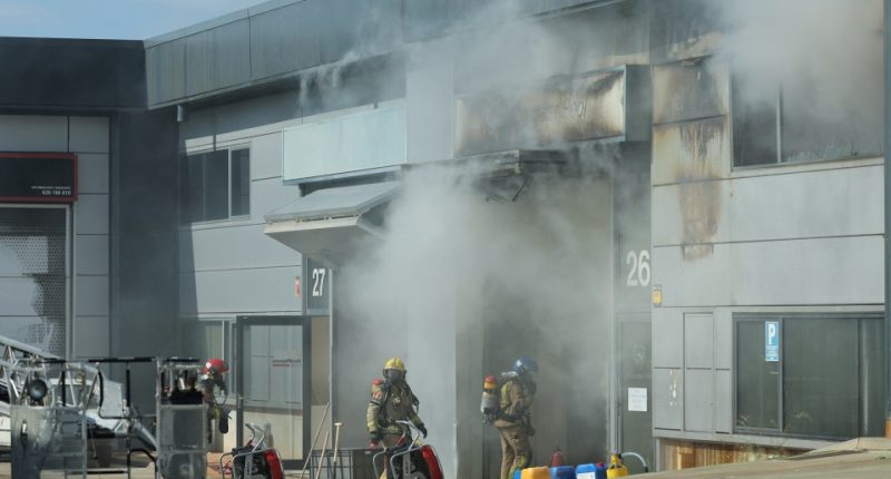 Firefighters at the site of a burning building.