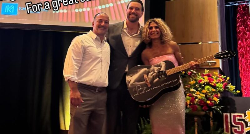 Travis Kelce poses with fans who bought Taylor Swift merch