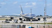 Boeing 747 on tarmac at Palm Beach International Airport with motorcade.