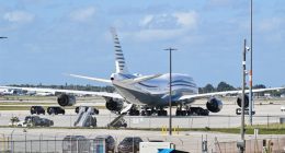 Boeing 747 on tarmac at Palm Beach International Airport with motorcade.