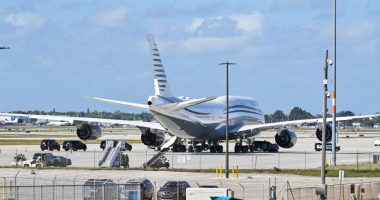 Boeing 747 on tarmac at Palm Beach International Airport with motorcade.