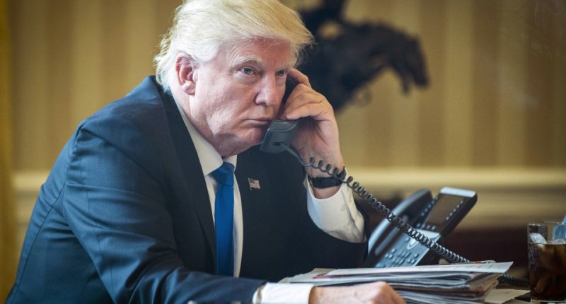 President Donald Trump on the phone in the Oval Office.