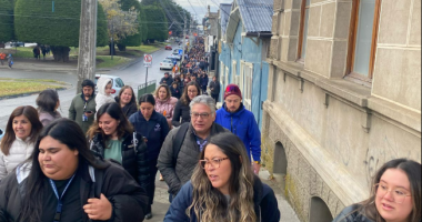 Large group of people walking down a street.