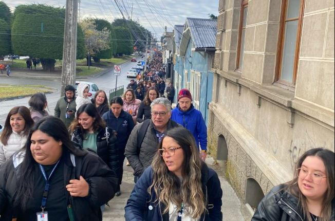 Large group of people walking down a street.