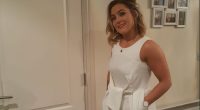 Woman in white jumpsuit and gold heels.