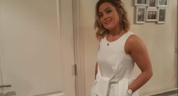 Woman in white jumpsuit and gold heels.