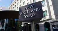 A sign stands in front of the New Scotland Yard, the headquarters of the London Metropolitan Police