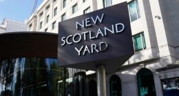 A sign stands in front of the New Scotland Yard, the headquarters of the London Metropolitan Police