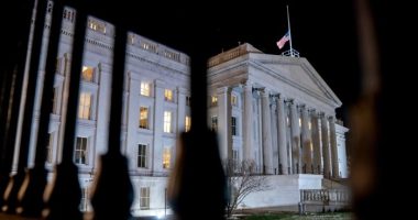 The front facade of the US Treasury building is pictured lit up at night