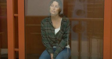 Ksenia Karelina sitting in a courtroom cage.