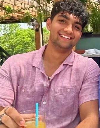 Man in pink shirt holding a cocktail.