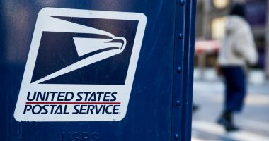 USPS logo on a blue mailbox.