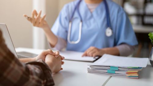 Close-up hand image of a serious patient having a medical consultation with a professional doctor at a hospital. Medical checkup, counseling, and diagnosis of disease