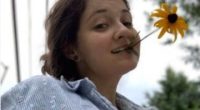 Emily Sommer holding a flower in her mouth.