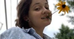Emily Sommer holding a flower in her mouth.