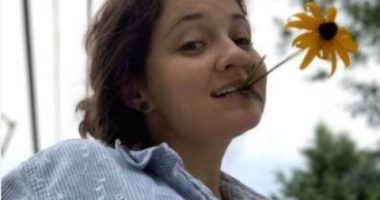 Emily Sommer holding a flower in her mouth.