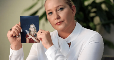 Woman holding a photograph of a younger woman.
