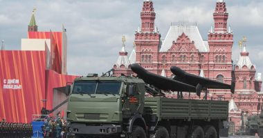 Armored vehicle carrying drones in a military parade.
