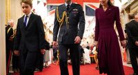 Prince George walks in front of his parents as they arrive for a tea party organised for the veterans at Buckingham Palace on Monday