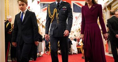 Prince George walks in front of his parents as they arrive for a tea party organised for the veterans at Buckingham Palace on Monday
