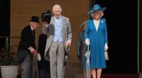 The monarch, 76, looked dapper in his grey and baby blue three-piece suit as he looked out over thousands of people who arrived for the event at Buckingham Palace on Wednesday afternoon