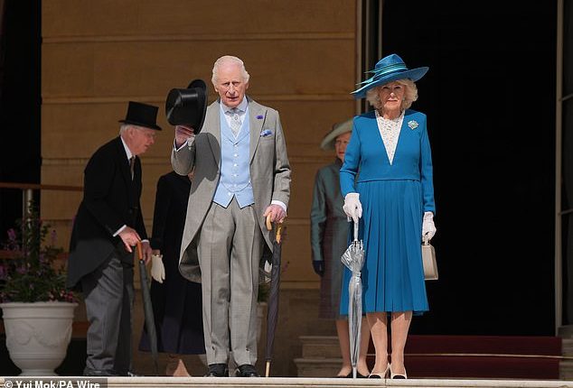 The monarch, 76, looked dapper in his grey and baby blue three-piece suit as he looked out over thousands of people who arrived for the event at Buckingham Palace on Wednesday afternoon