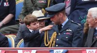 Prince Louis was quick to help out his father Prince William as he brushed down the future King's military uniform at the VE Day celebration at Buckingham Palace today