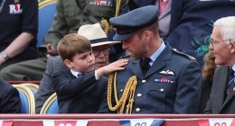 Prince Louis was quick to help out his father Prince William as he brushed down the future King's military uniform at the VE Day celebration at Buckingham Palace today