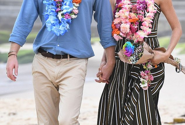 Prince Harry and Meghan Markle walk along Bondi Beach in Sydney, Australia, in 2018