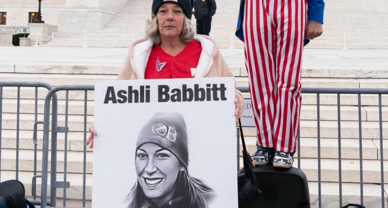 FILE - Micki Witthoeft, center, mother of Ashli Babbitt, the woman fatally shot by police inside the U.S. Capitol during the Jan. 6, 2021, riot, joins protesters outside of the Supreme Court on the second anniversary of the Jan. 6, assault on the U.S. Capitol, in Washington,, Jan. 6, 2023. (AP Photo/Jose Luis Magana)
