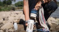 Invasive Species Specialist Maddie Baker holds a plankton tow in her hand.