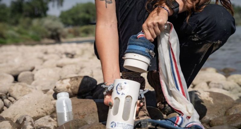 Invasive Species Specialist Maddie Baker holds a plankton tow in her hand.