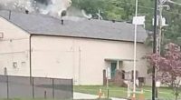 Screenshot of a car crashing through a building's roof.