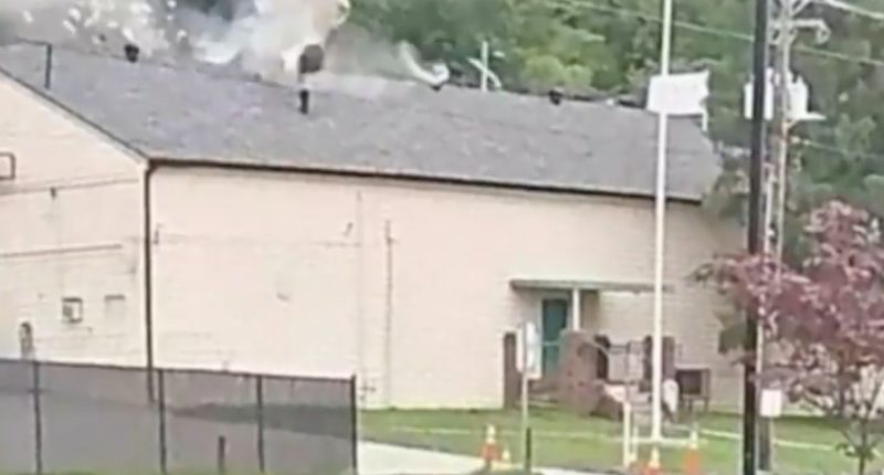 Screenshot of a car crashing through a building's roof.