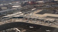 Aerial view of airplanes parked at gates in an airport terminal.