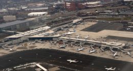 Aerial view of airplanes parked at gates in an airport terminal.