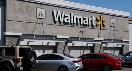 Walmart store exterior with cars parked in front.