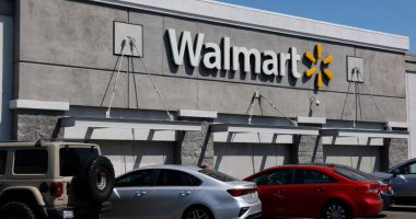 Walmart store exterior with cars parked in front.