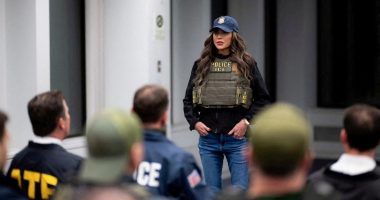 Secretary Kristi Noem in ICE vest briefing law enforcement.
