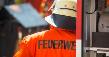 Back of a German firefighter's orange jacket with "FEUERWEHR" printed on it.
