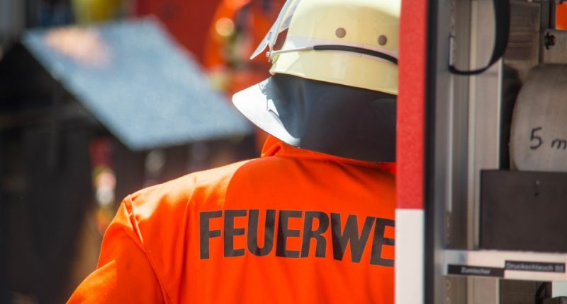 Back of a German firefighter's orange jacket with "FEUERWEHR" printed on it.